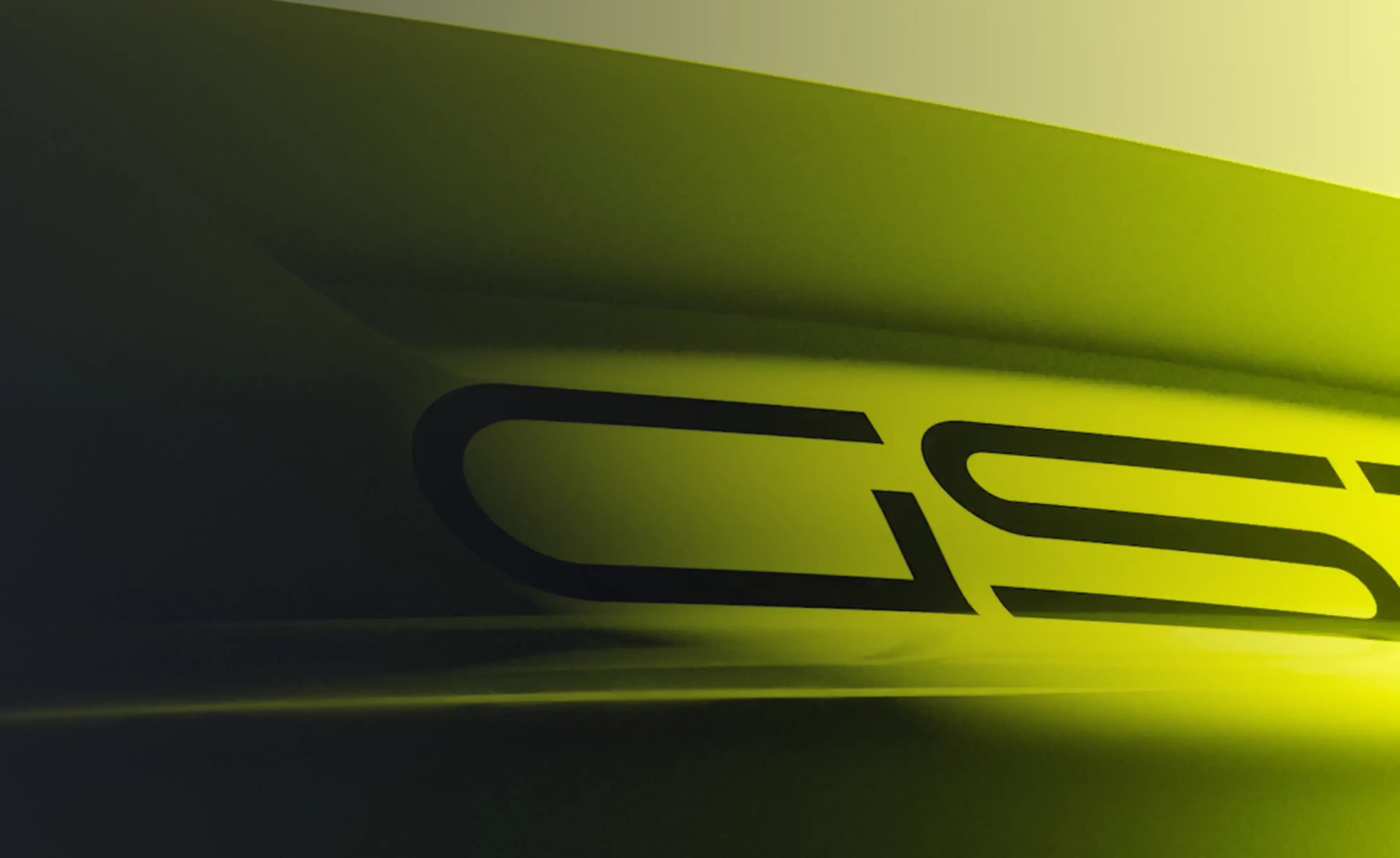 Nahaufnahme einer neongelb-grünen Karosseriefläche mit dem stilisierten 'GS'-Schriftzug in dunkler Schrift, wobei dramatische Beleuchtung die geschwungene, aerodynamische Oberfläche hervorhebt.